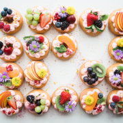 Rosquillas variadas decoradas con diferentes frutas, flores y glaseado